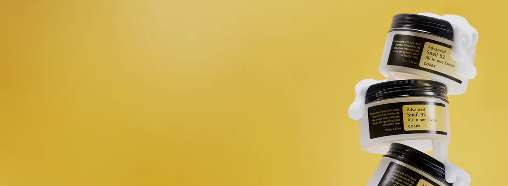 COSRX Advanced Snail 92 All in One Cream 100 g jars on a yellow product background