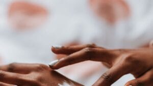 Black woman applying a small amount of skincare product to her hand
