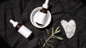 Unlabeled skincare bottles and gua sha for a toner vs essence guide